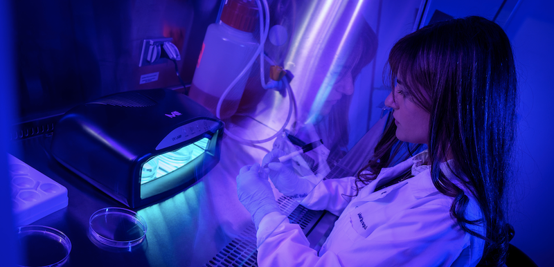 Dr Maria Zhivagui labelling petri dishes to be placed in a UV curing device
